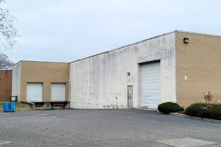 Commercial Building Inspections in New York, Three Inspector workers in safety gear look up at a building